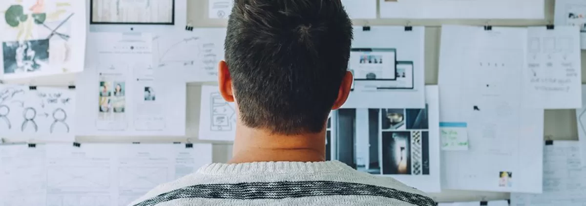 Man thinking in front of the wall with stickers